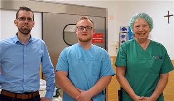 Zwei Männer und eine Frau (rechts) in einem Krankenhaus. Sam Thümler (Mitte) begann jetzt als erster Auszubildender die ATA-Ausbildung im St.-Bernhard-Hospital.in Brake. Mit ihm freuen sich Pflegedienstleiter Dirk Schrage (links) und Birgit Neese (Leitung OP-Pflege). 