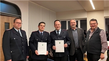 Fünf Männer blicken in eine Kamera.