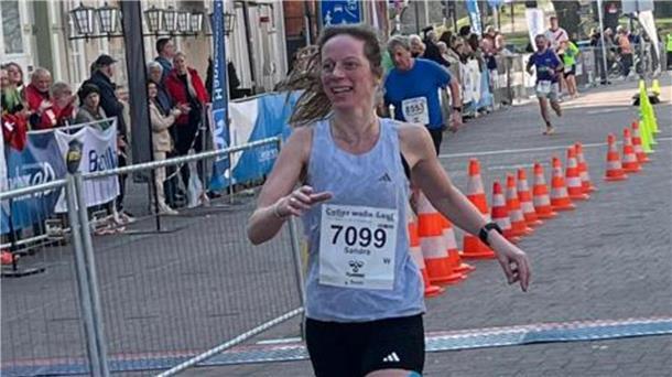 Frau in Sportkleidung läuft in Innenstadt ins Ziel