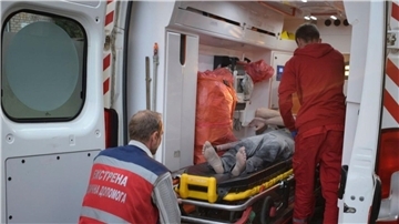 Sanitäter bereiten den Transport eines verletzten Mannes in eine naheliegende Klinik vor.