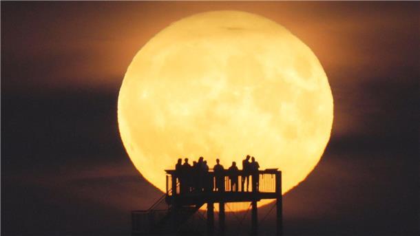 Sonne, Mond und Sterne im August - Gleich zweimal Vollmond Schaulustige beobachten vom Aussichtsturm auf dem Hohen Berg in Niedersachsen den Mondaufgang (Archivbild).
