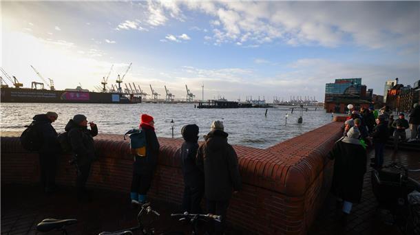 Nach Sturmtief: Heftige Regenfälle und Schnee erwartet Schaulustige beobachten von einer Promenade am Hamburger Fischmarkt die Überflutung durch die Sturmflut.