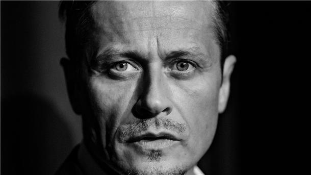 Ein Mann schaut in die Kamera.