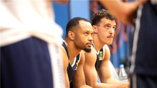 Zwei Basketballer der Eisbären Bremerhaven sitzen auf der Ersatzbank.