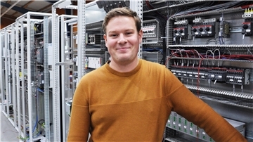 Christian Diekmann vor einer Schaltanlage voller Elektronik