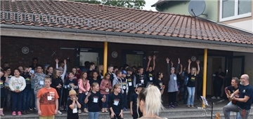Schülerinnen und Schüler der Grundschule St. Willehad begrüßten mit fröhlichem Gesang, unterstützt von Lehrkräften, die Besucherinnen und Besucher des Sommerfestes.