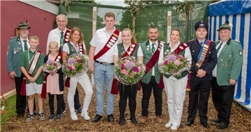 Eine Gruppe von Menschen in Schützenkleidung sind nebeneinander aufgereiht.
