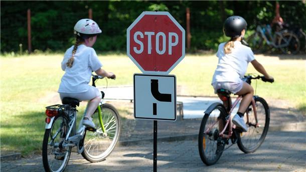 Schulkinder fahren auf einem Parcours.