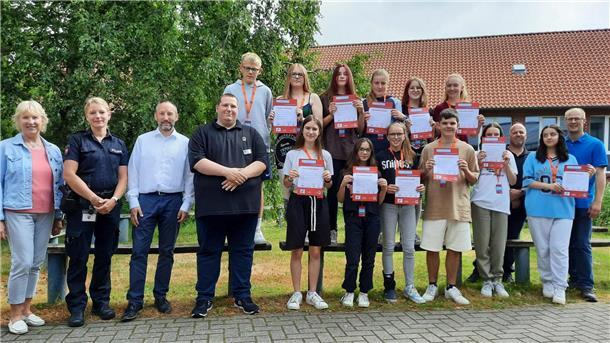 Schulleiterin Ilona Seebeck, Christina Hoffmann von der Polizei Nordenham, Uwe Kesting für den Landkreis Wesermarsch, die VBN-Mobilitätstrainer Sebastian Jacobs und André Gieschen sowie Sozialpädagoge Florian Vollprecht (v. l.) übergaben den frisch ausgebildeten Schulbusbegleitern der Zinzendorfschule ihre Ausweise.
