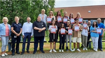 Schulleiterin Ilona Seebeck, Christina Hoffmann von der Polizei Nordenham, Uwe Kesting für den Landkreis Wesermarsch, die VBN-Mobilitätstrainer Sebastian Jacobs und André Gieschen sowie Sozialpädagoge Florian Vollprecht (v. l.) übergaben den frisch ausgebildeten Schulbusbegleitern der Zinzendorfschule ihre Ausweise.