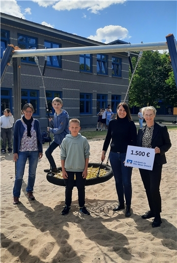 Schulleiterin Sandra Pohl (Zweite von rechts) freut sich mit den Schülern Birk und Lukas über die langersehnte Nestschaukel an der KGS Tarmstedt.
