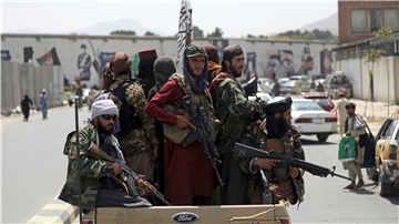 Taliban mit Gewehren auf einem Fahrzeug.