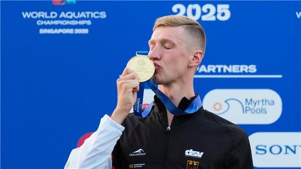 Schwimmer Florian Wellbrock küsst seine Goldmedaille. Die hat er sich gerade bei der Schwimm-WM im Land Singapur geholt.