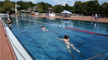 Schwimmerinnen ziehen im Becken im Sommerbad Pankow ihre Bahnen. Zum Schutz der Badegäste werden Streitschlichter des Konfliktlotsen-Projekts „Cool am Pool“ eingesetzt. Bei dem seit elf Jahren bestehenden Projekt werden Konflikt-Lotsen eingesetzt, um Auseinandersetzungen in Freibädern zu verhindern.