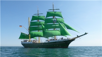 Ein Schiff mit grünen Segeln.