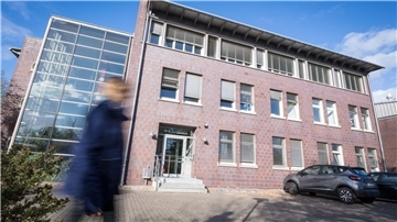 Mann geht an einem Gebäude vorbei