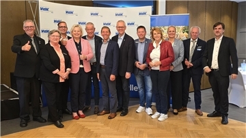 Eine Gruppe von Damen und Herren stehen für ein Foto zusammen. 