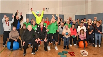 Bunte Gruppe von Gesundheitssportlerinnen und -sportlern in der Turnhalle