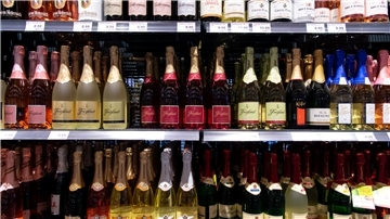 Sektflaschen von verschiedenen Herstellern stehen in einem Supermarktregal.