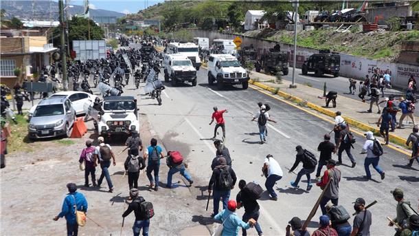 Mexiko: 13 Polizisten und Beamte als Geiseln genommen Sicherheitskräfte werden auf eine Autobahn von Demonstranten mit Steinen beworfen.