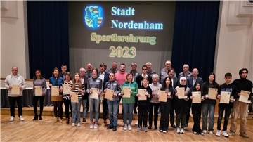 Größere Gruppe Menschen in einer Stadthalle