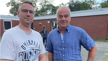 Zwei Männer auf einem Schulhof, Dennis Kittel und Bernd Maibaum von der Zinzendorfschule in Tossens.