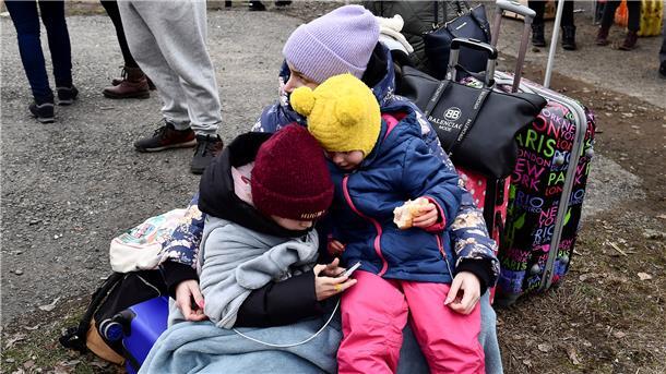 Sie bringen sich in Sicherheit: Eine Frau umarmt zwei Kinder auf der Flucht aus der Ukraine.
