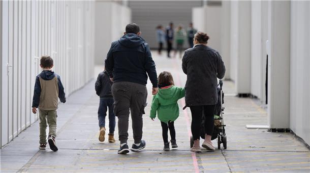 Eine Familie mit vier Kindern geht durch eine Halle.