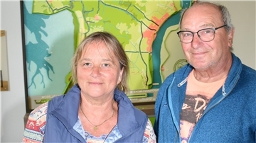 Eine Frau und ein Mann stehen in einem Museum vor einem Modell, das Butjadingen zeigt.