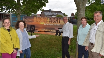 Sie weisen auf ein Banner für die „Nacht der Acht“ am Sonnabend in Butjadingen hin (von links): Julia Poustourlis und Susanne Hübler vom Kirchenteam Waddens, der katholische Pastor Michael Kenkel, Pastorin Susanne Stephan und Pastor Dietmar Reumann-Claßen.
