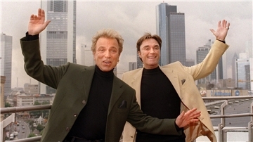 Siegfried & Roy reißen die Arme in die Höhe. Apple TV+ plant jetzt eine Serie über das Leben des Magier-Duos.