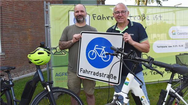 Zwei Männer halten ein Verkehrszeichen hoch