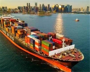 Ein Containerschiff nimmt Fahrt auf vor der Skyline von Singapur.