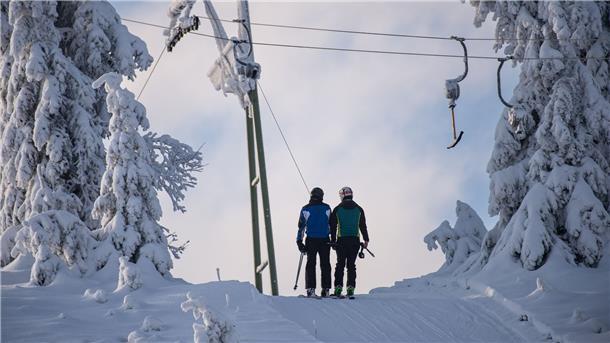 Skifahrer lassen sich am Sonnenberg im Oberharz mit einem Schlepplift den Berg hochziehen.