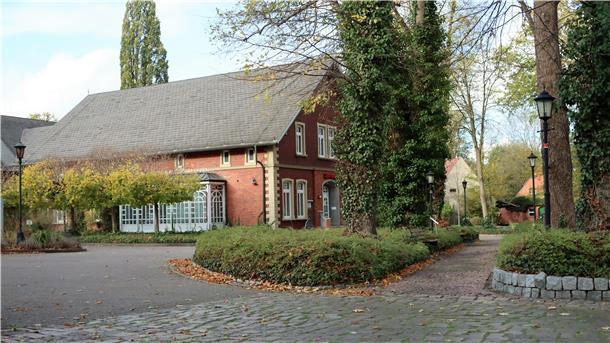 Umbau in Wilstedt: Apotheke und Sparkassenbereich bald wieder geöffnet Haus mit Pflasterweg und Bäumen