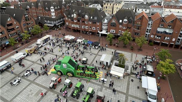 Eine Luftaufnahme zeigt den Nordenhamer Marktplatz mit dutzenden Menschen, Traktoren und Ständen. 