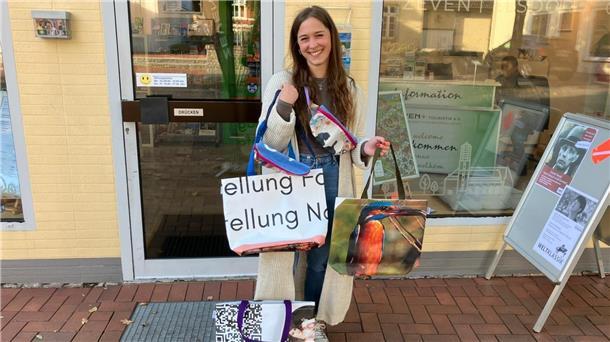 Eine junge Frau hat sich mehrere Taschen umgehängt. 
