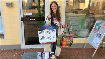 Eine junge Frau hat sich mehrere Taschen umgehängt. 