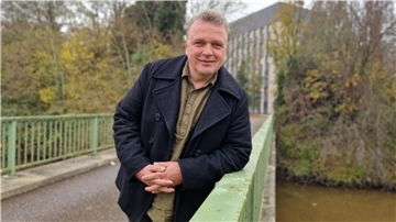 Ein Mann lehnt auf dem Geländer eine Brücke
