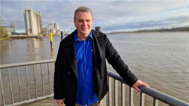 Ein Mann steht in Brake an der Weser. Im Hintergrund ist der Hafen zu sehen. Das Foto zeigt Sönke Hofmann vom Klimaschutzmanagement-Team des Landkreises Wesermarsch.