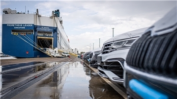 Export-Autos parken vor einem Schiff auf der Kaje. 