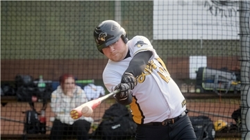 Ein Baseballer schlägt den Ball.