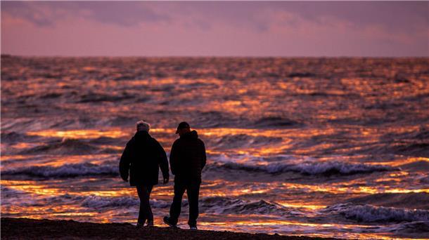 Bilder des Tages Spaziergänger sind nach Sonnenuntergang am Strand von Warnemünde an der Ostsee unterwegs.