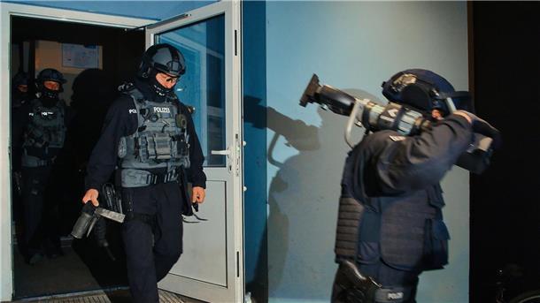 Razzien gegen Schleuser in Berlin und Brandenburg Spezialkräfte verlassen bei einer großangelegten Razzia der Bundespolizei und Landespolizei Brandenburg ein Haus in Weißensee.