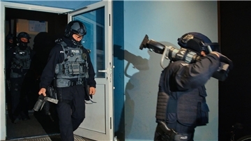 Spezialkräfte verlassen bei einer großangelegten Razzia der Bundespolizei und Landespolizei Brandenburg ein Haus in Weißensee.