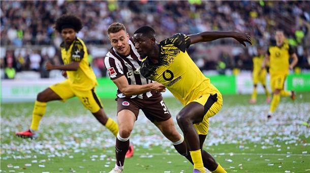 St. Paulis Hauke Wahl (l) im Zweikampf mit BVB-Stürmer Serhou Guirassy.
