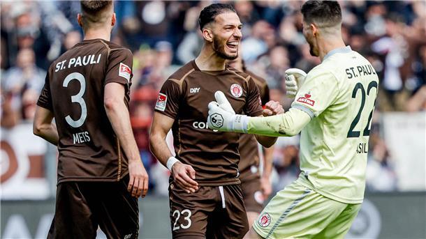 St. Paulis Karol Mets (von links), Leart Paqarada und Torwart Nikola Vasilj feiern den Treffer zum 1:0.