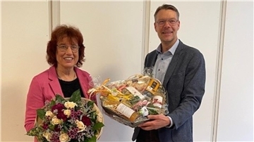 Stadtdirektor Henning Fricke verabschiedet Elke Seifert mit einem Präsentkorb und einem Blumenstrauß. ,