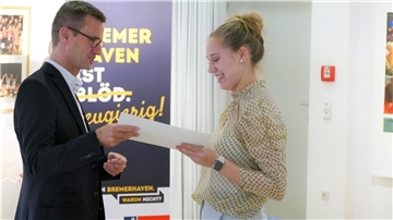 Stadtrat Michael Frost überreicht Bea Hancken die Urkunde für das Lehramtsstipendium. 