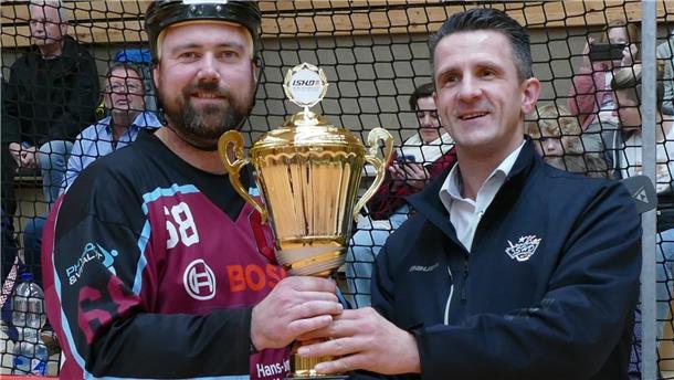 Staffelleiter Carsten Arndt (rechts) übergibt Kapitän Dennis Lütjen von den Bremerhaven Whales den Meisterpokal.